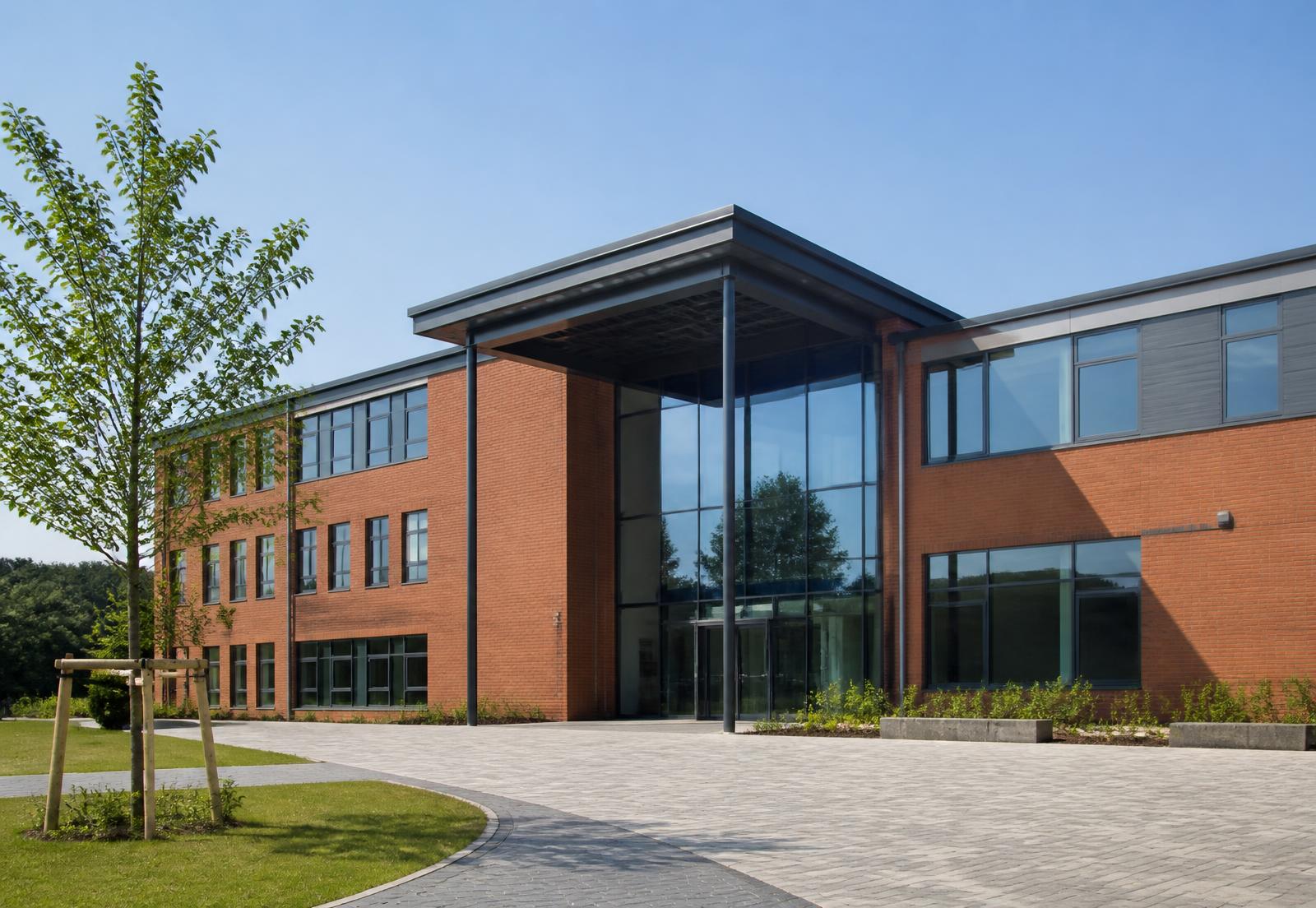 The main entrance of a modern British school building on a sunny day